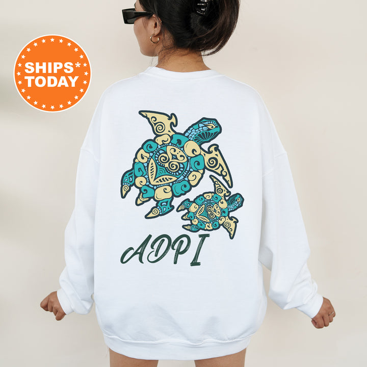 A person wearing a white sweatshirt with a colorful turtle design and the text "ADPI" printed on it.