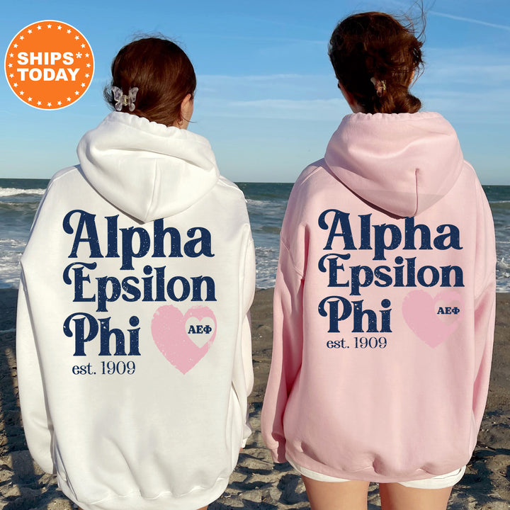 two women wearing pink and white hoodies on the beach