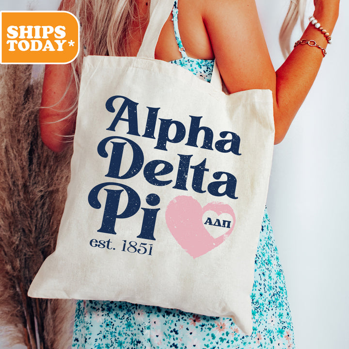 a woman holding a tote bag with a heart on it