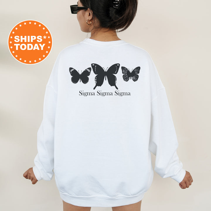 a woman wearing a white sweatshirt with black butterflies on it