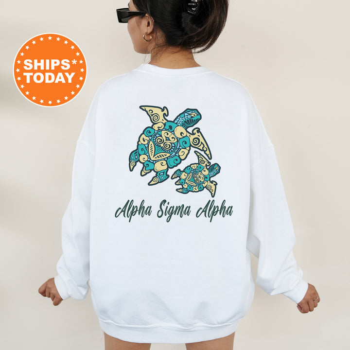 A woman wearing a white sweatshirt with a graphic of a turtle and the text "Alpha Sigma Alpha" printed on it.