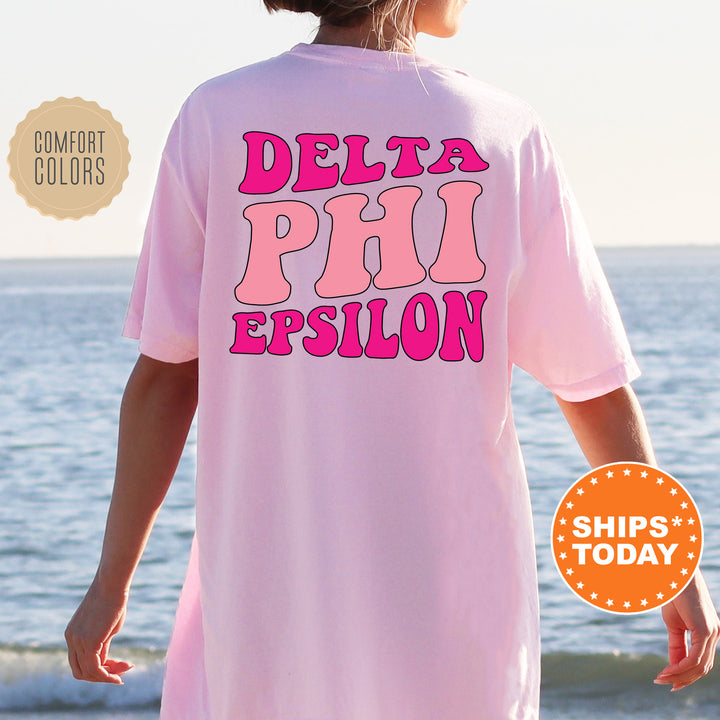 a woman wearing a pink shirt that says delta phi epiloon