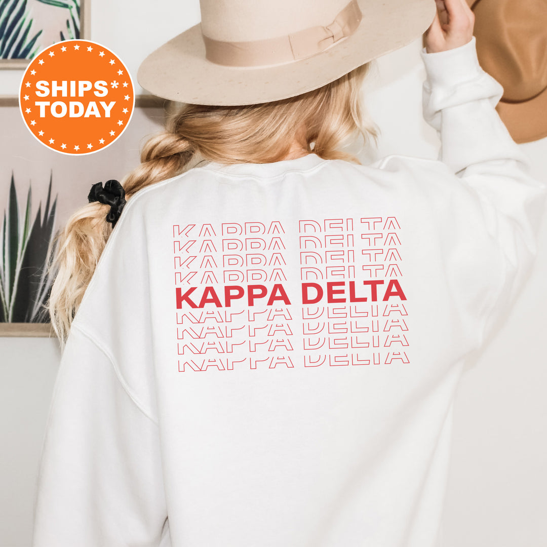 a woman wearing a white sweatshirt with the words kapa delta printed on it