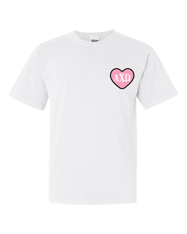 a white t - shirt with a pink heart on the chest