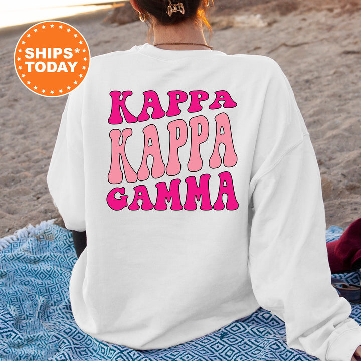 a woman sitting on the beach wearing a sweatshirt that says kappa kapp