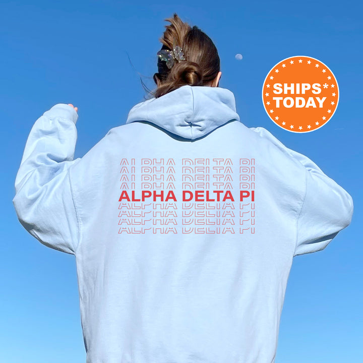 a woman wearing a white hoodie with the words alpha delta pi on it