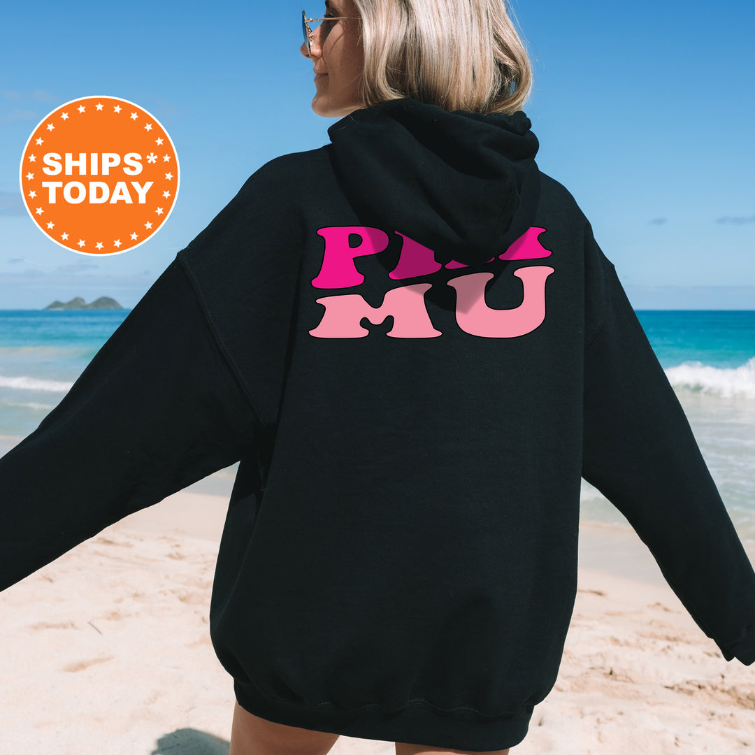 a woman wearing a black hoodie with pink letters on it
