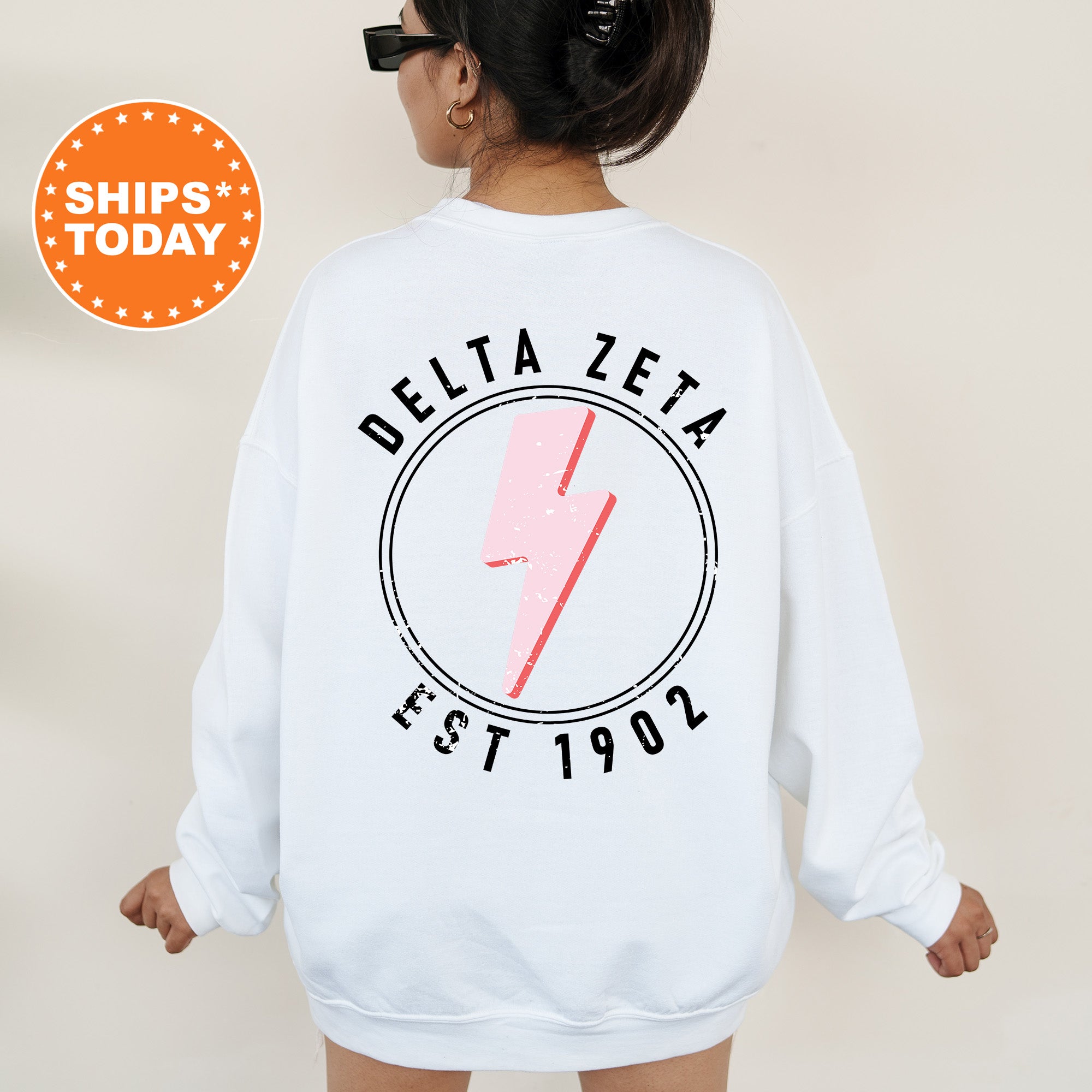 a woman wearing a white sweatshirt with a pink lightning bolt on it