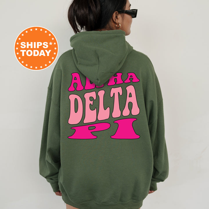 a woman wearing a green hoodie with pink letters on it