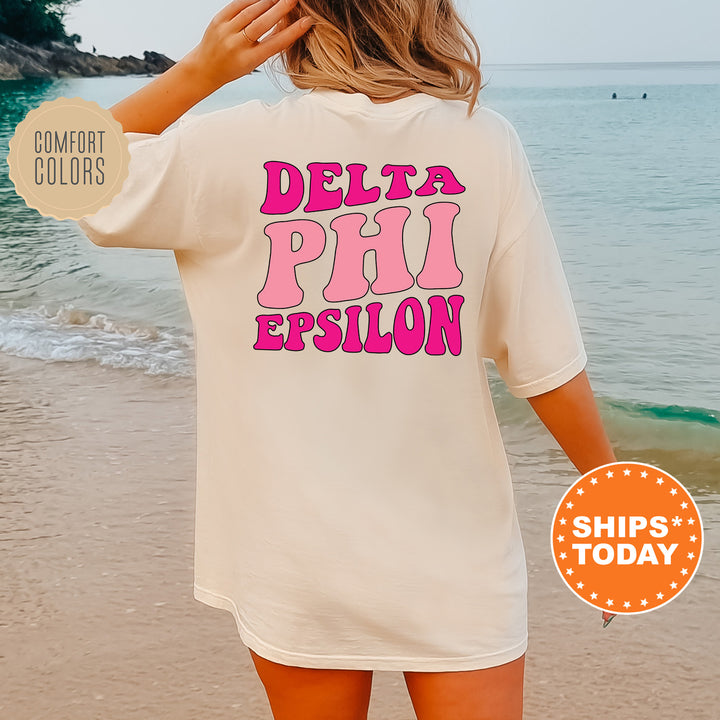 a woman standing on a beach wearing a white shirt that says delta piu eps