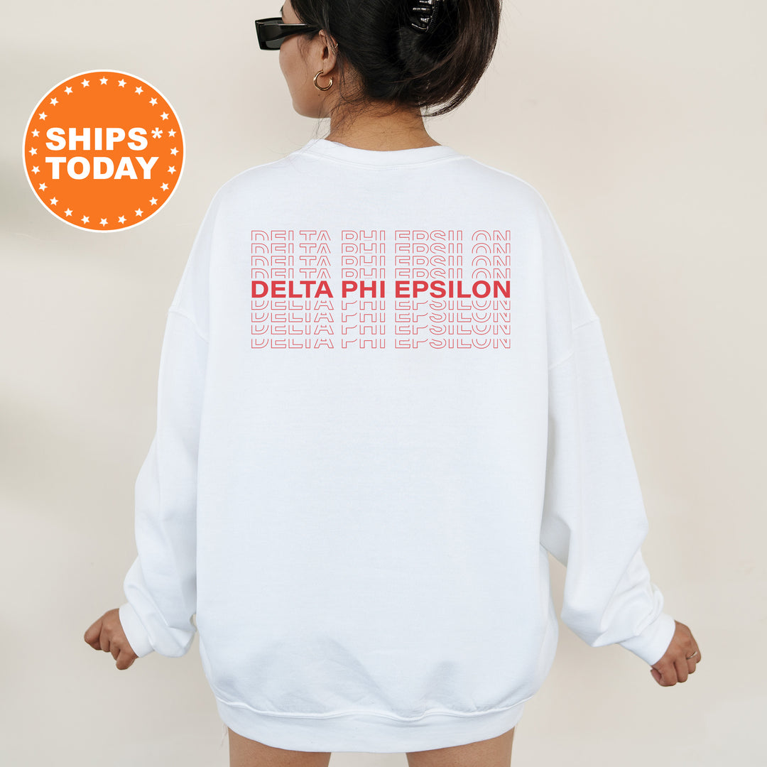 a woman wearing a white sweatshirt with the words delta phi epsilon printed on