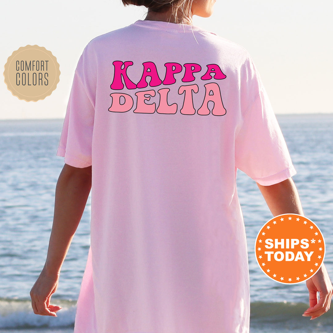 a woman wearing a pink shirt that says kapa delta