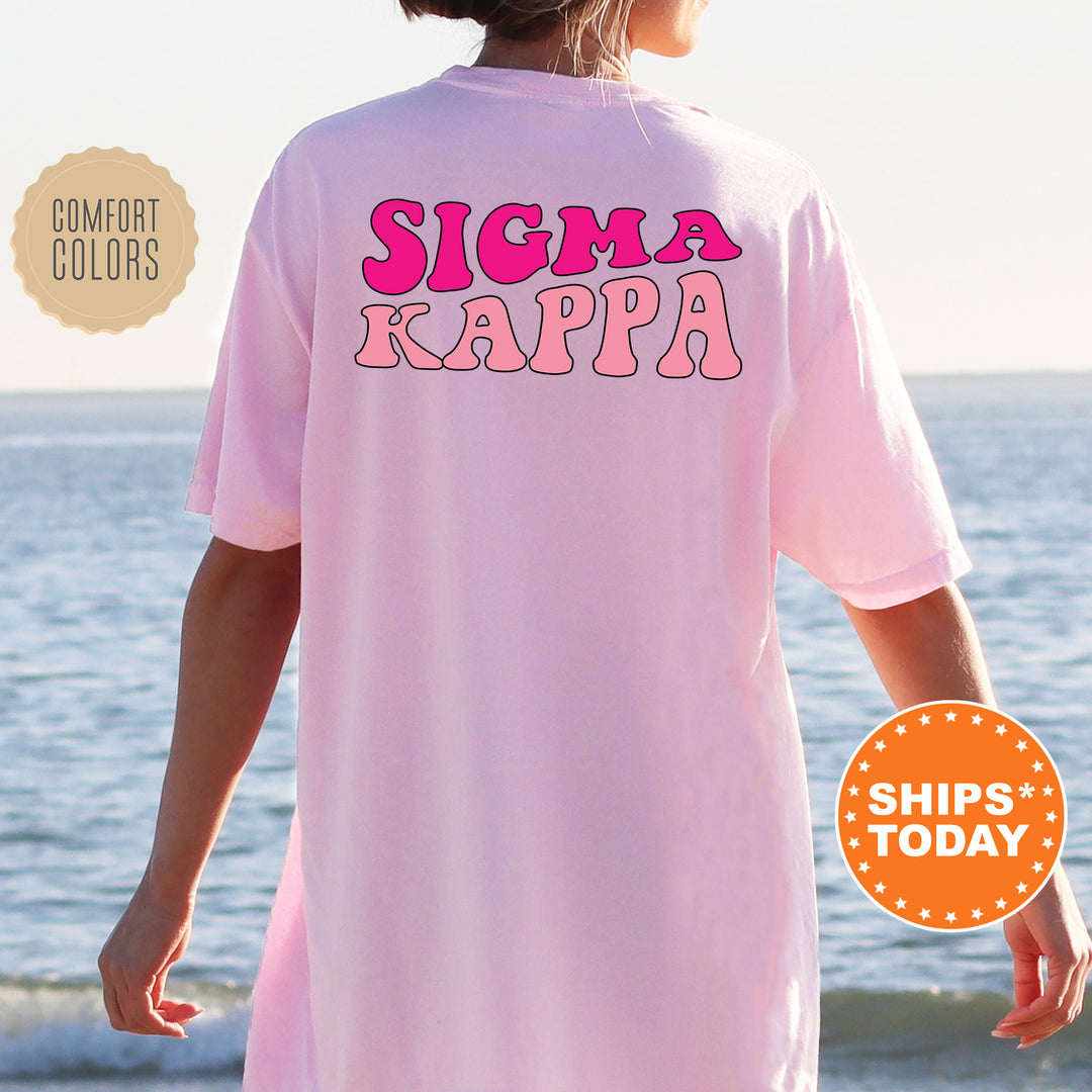 a woman wearing a pink shirt that says stigma kappa