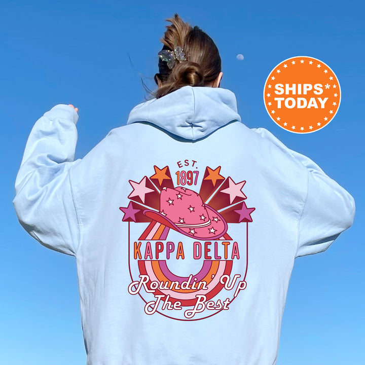 a woman wearing a white hoodie with the words kapa delta rounding up the