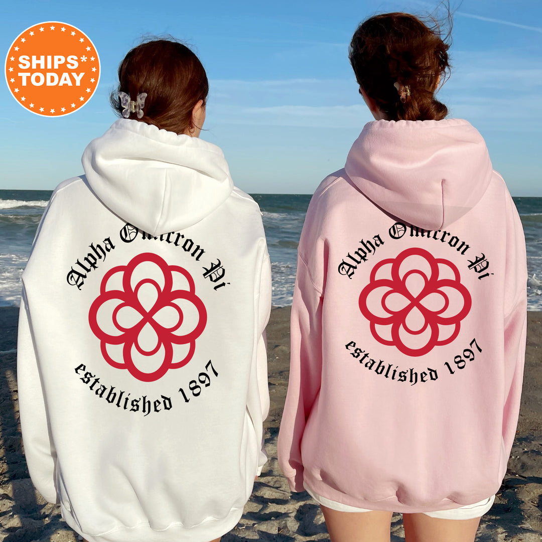 two women wearing matching sweatshirts on the beach