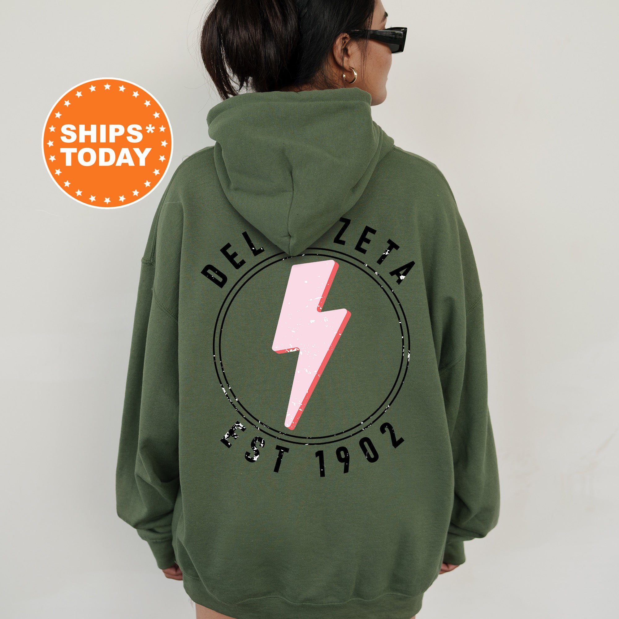 a woman wearing a green hoodie with a pink lightning bolt on it