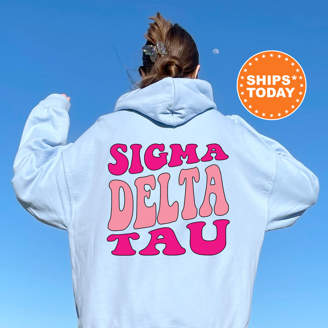a woman wearing a white hoodie with the words stigma delta tau printed on it