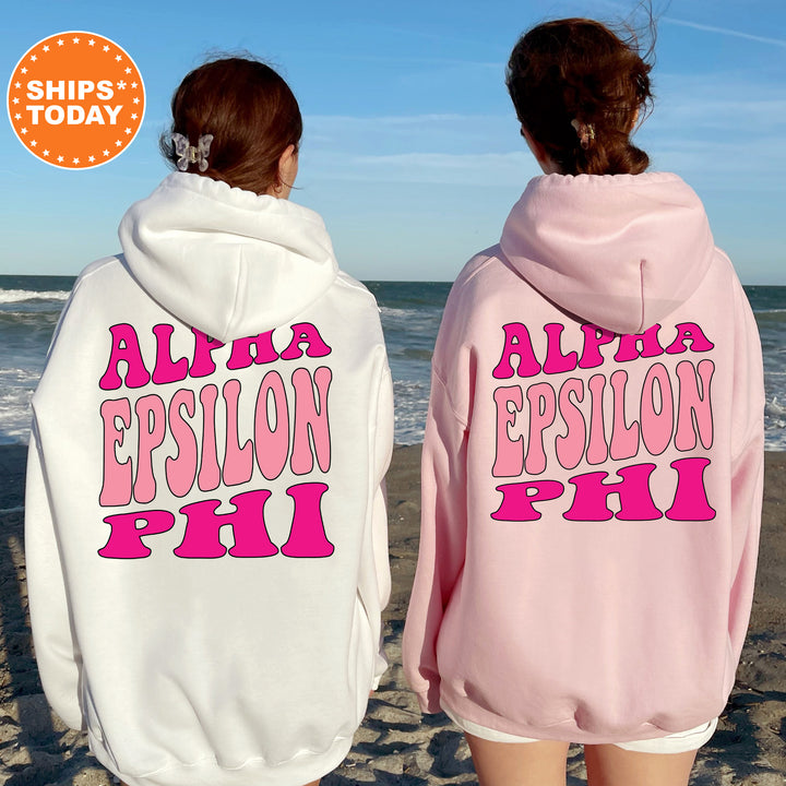 two girls wearing pink and white sweatshirts on the beach