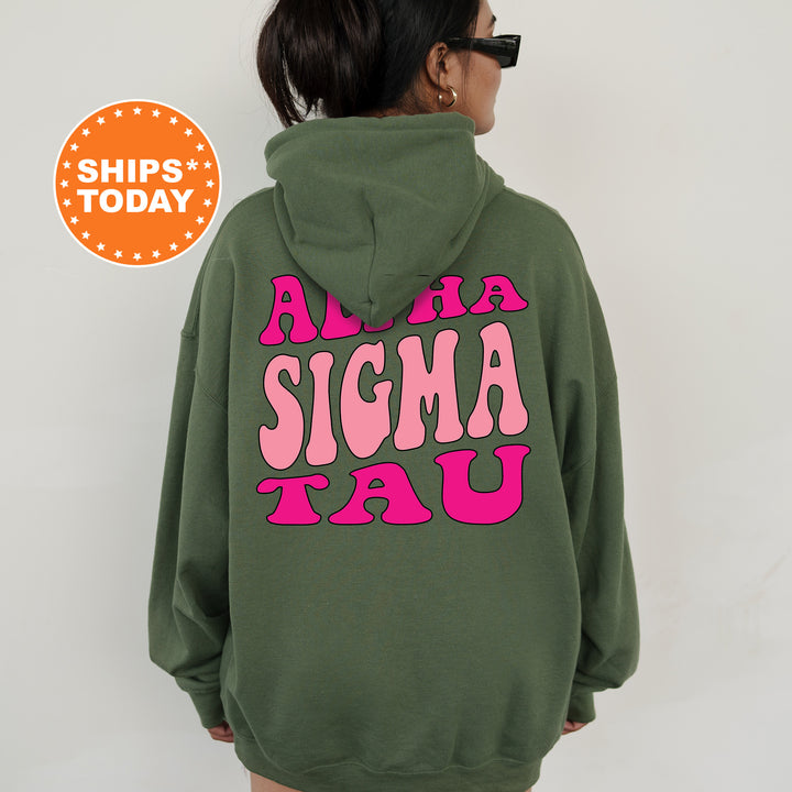 a woman wearing a green sweatshirt with pink letters on it