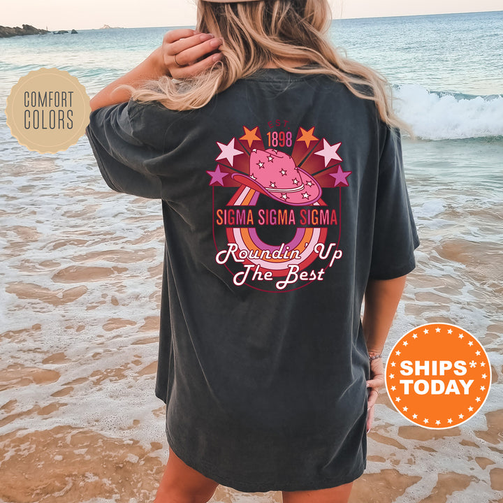 a woman standing on a beach wearing a black shirt