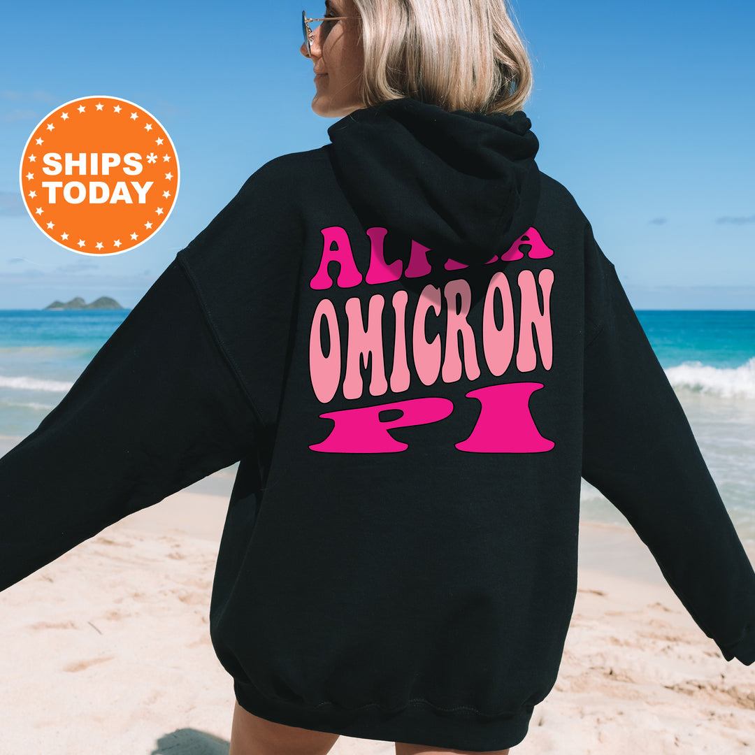 a woman in a black hoodie is walking on the beach