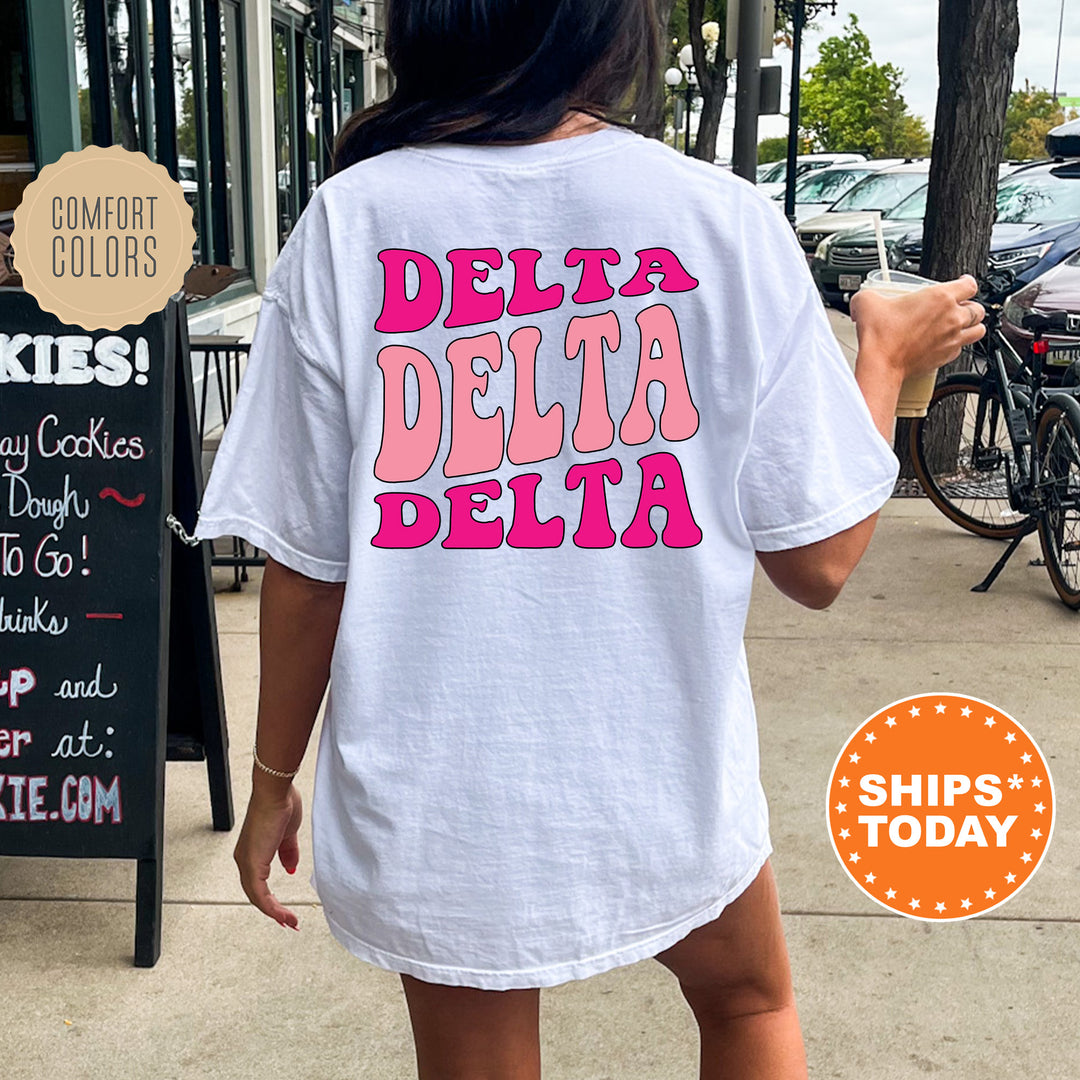 a woman walking down a sidewalk while wearing a t - shirt that says delta delta