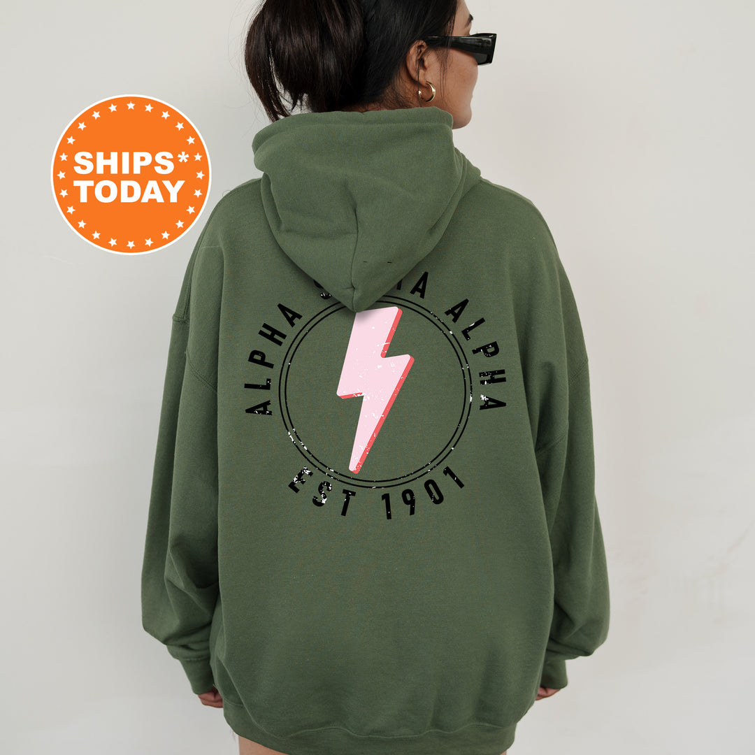 a woman wearing a green sweatshirt with a pink lightning bolt on it