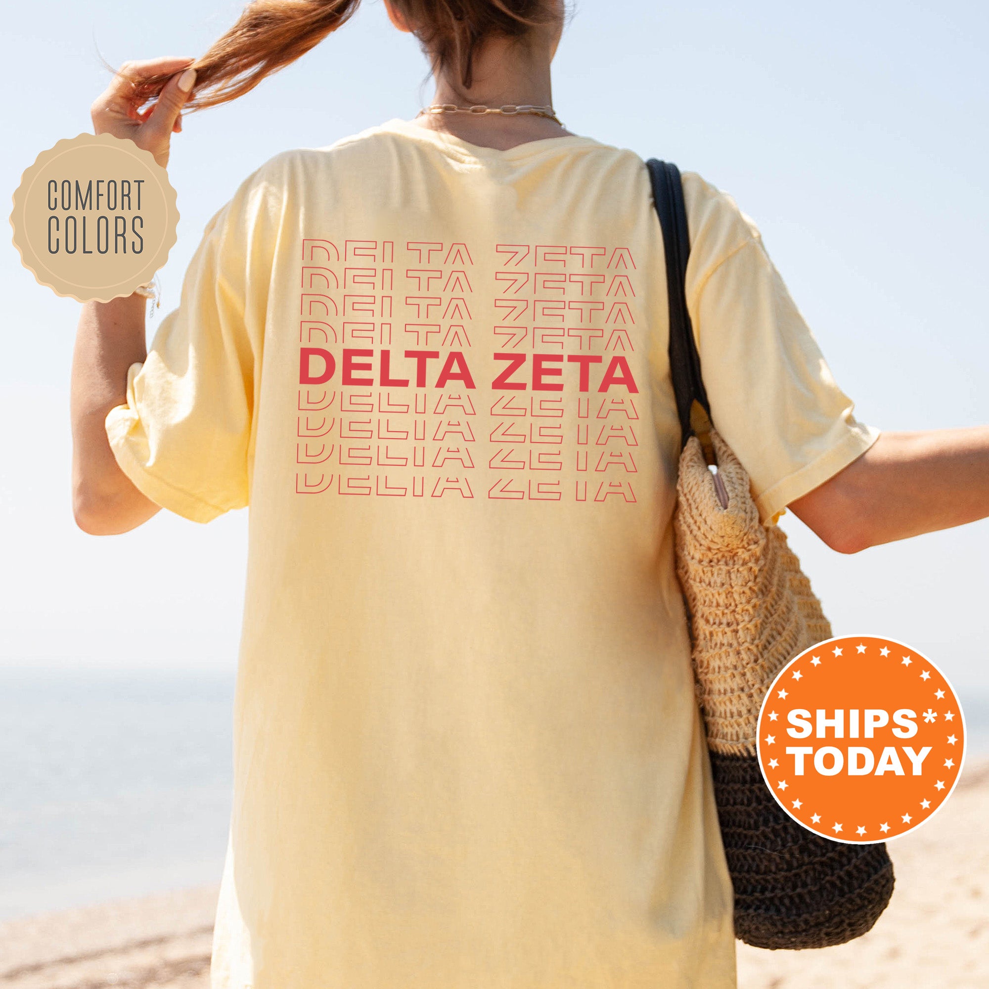 a woman holding a bag and a t - shirt with the words delta zeta
