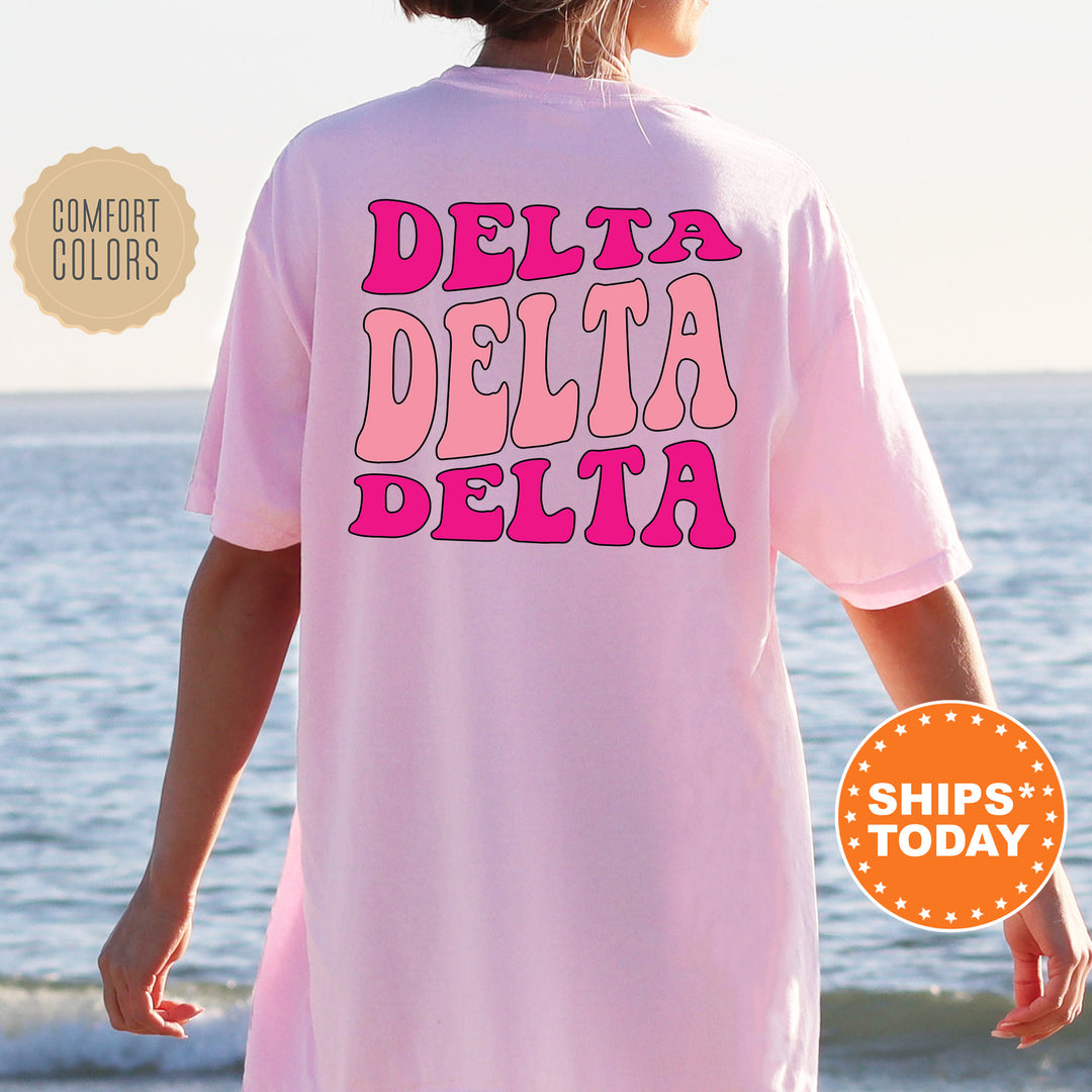 a woman wearing a pink shirt that says delta delta delta