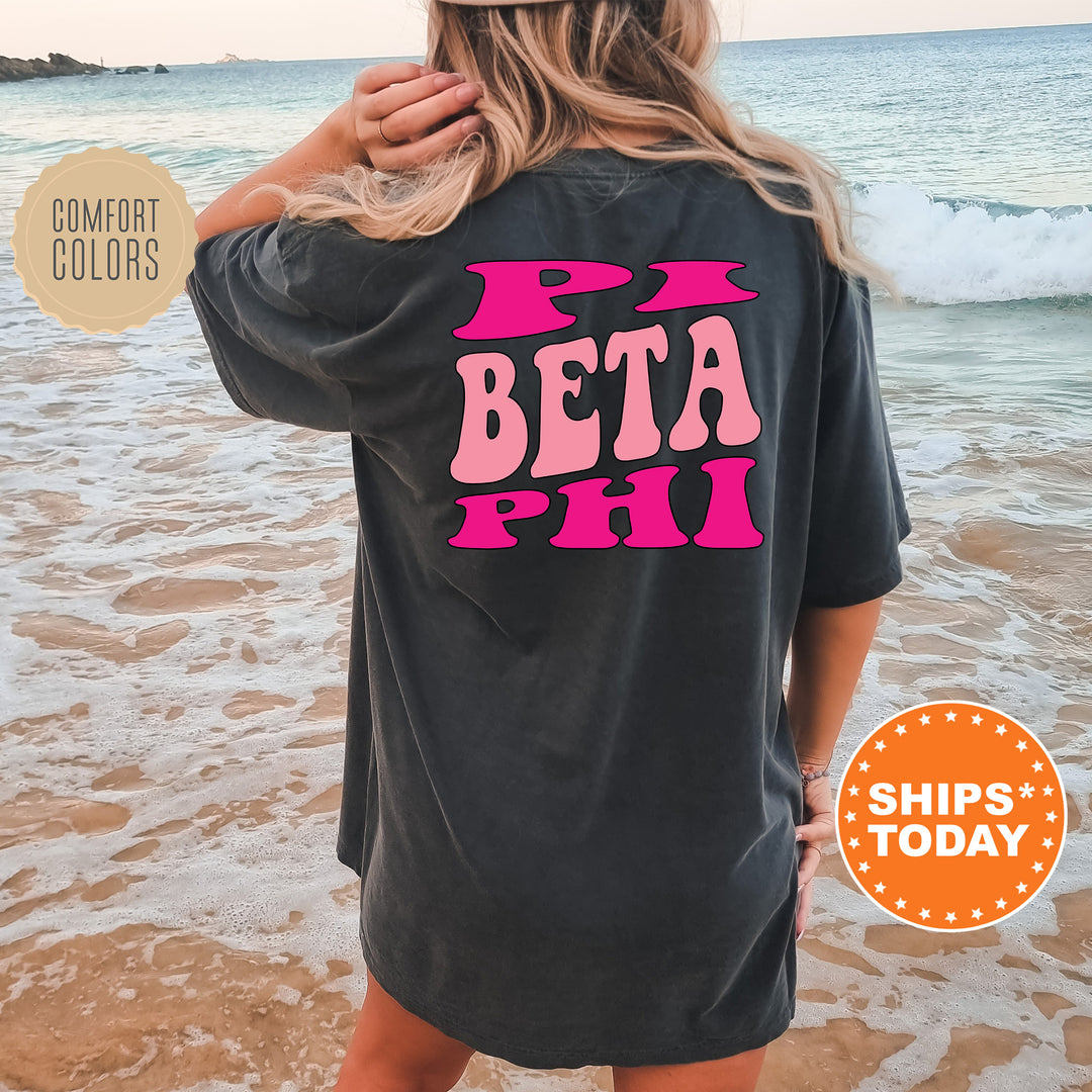 a woman standing on a beach wearing a t - shirt that says beta phi