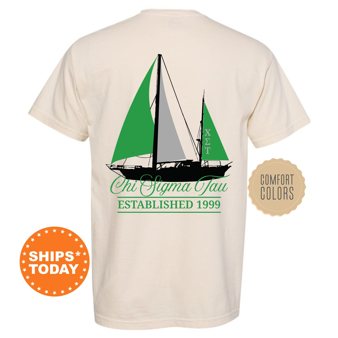 a white shirt with a green sailboat on it