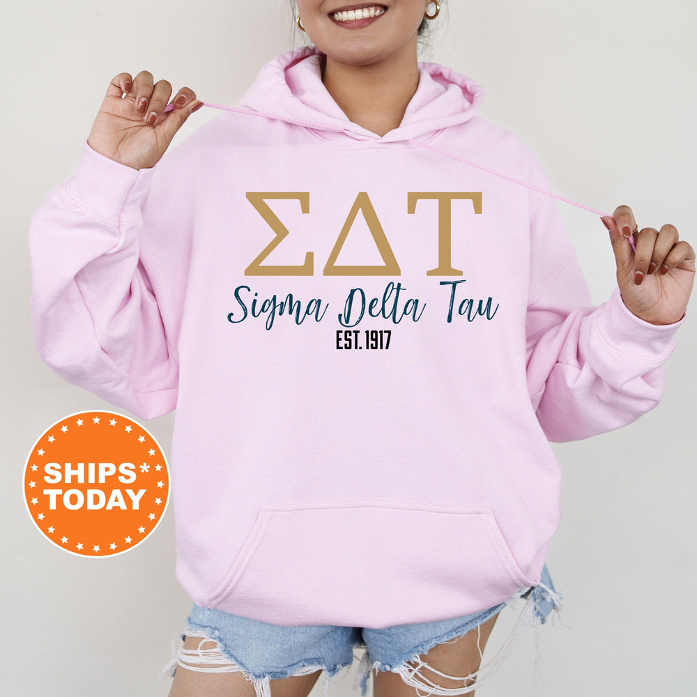a woman wearing a pink hoodie with the word zat on it