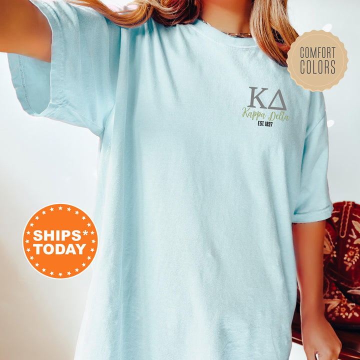 a woman wearing a light blue shirt with a k a logo on it