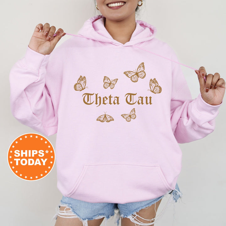 a woman wearing a pink hoodie with butterflies on it