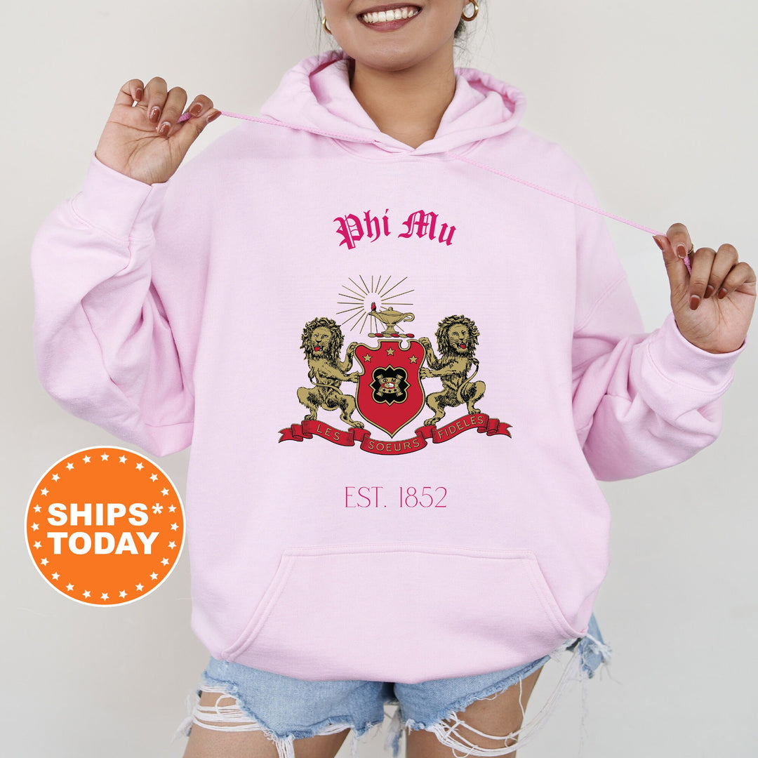 a woman wearing a pink hoodie with a crest on it