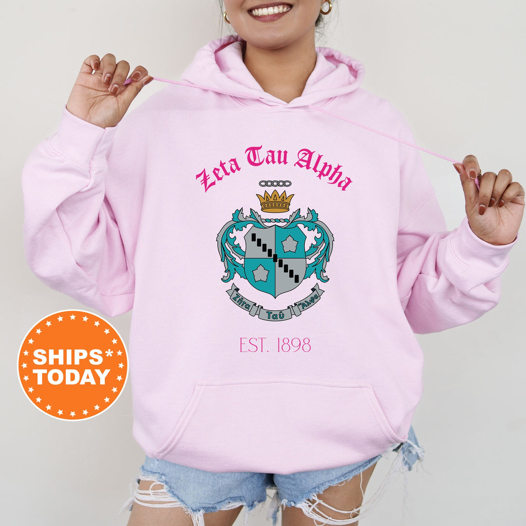 a woman wearing a pink hoodie with a crown on it