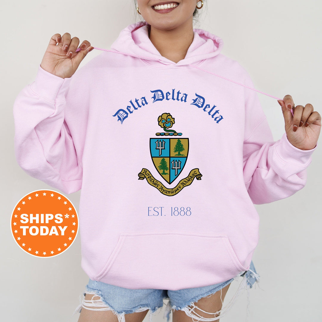 a woman wearing a pink hoodie with a blue and yellow crest on it