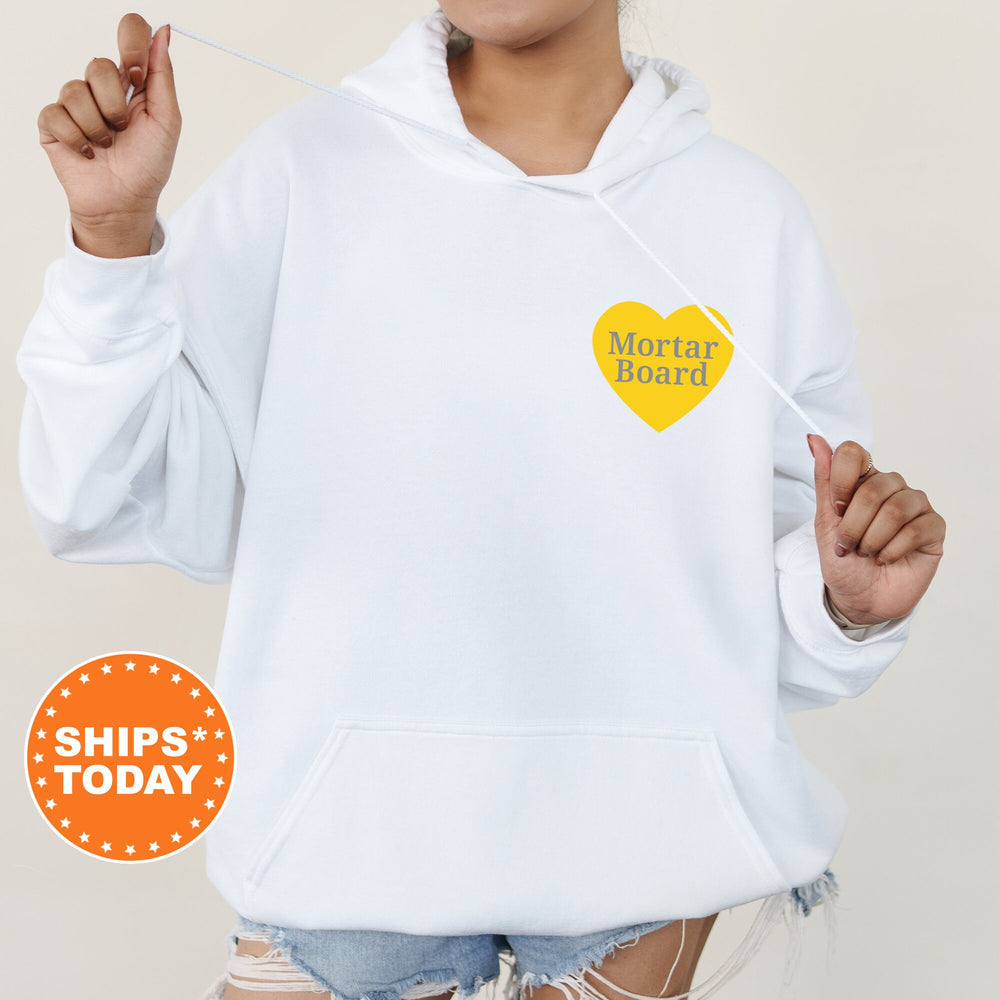 a woman wearing a white hoodie with a yellow heart on it