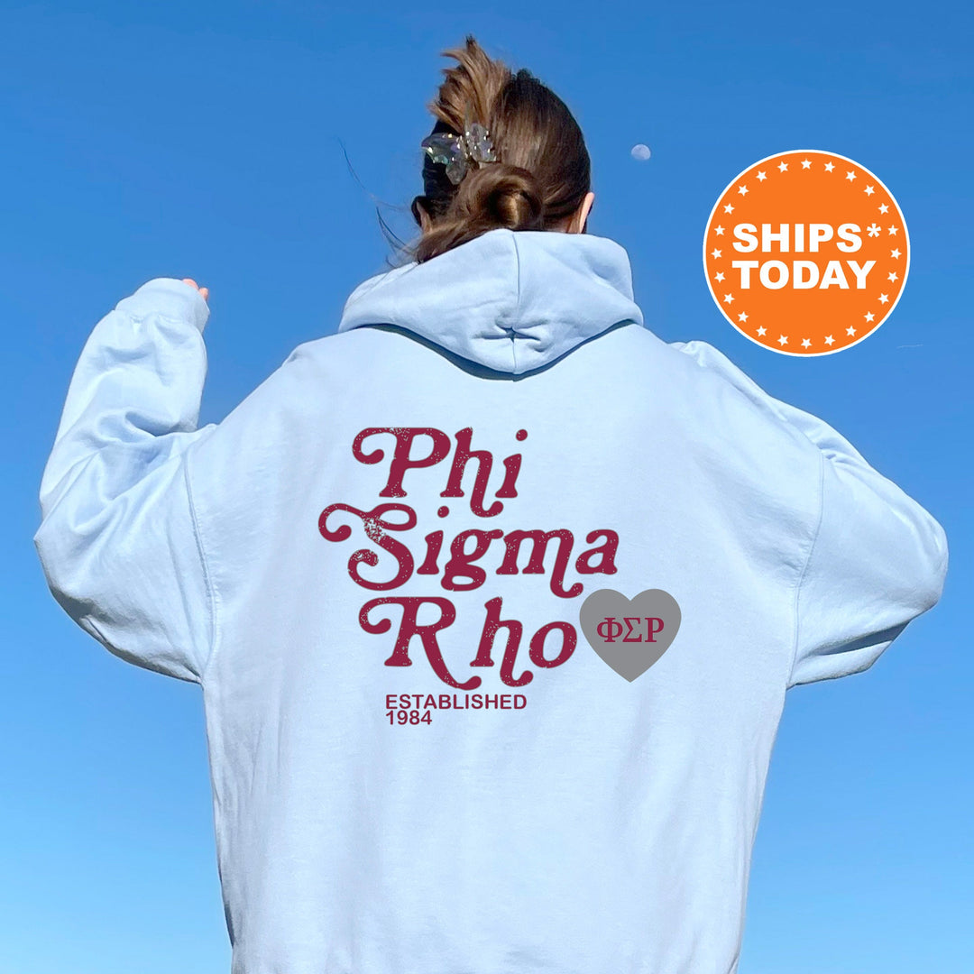 a woman wearing a white hoodie with phi sigma rho on it