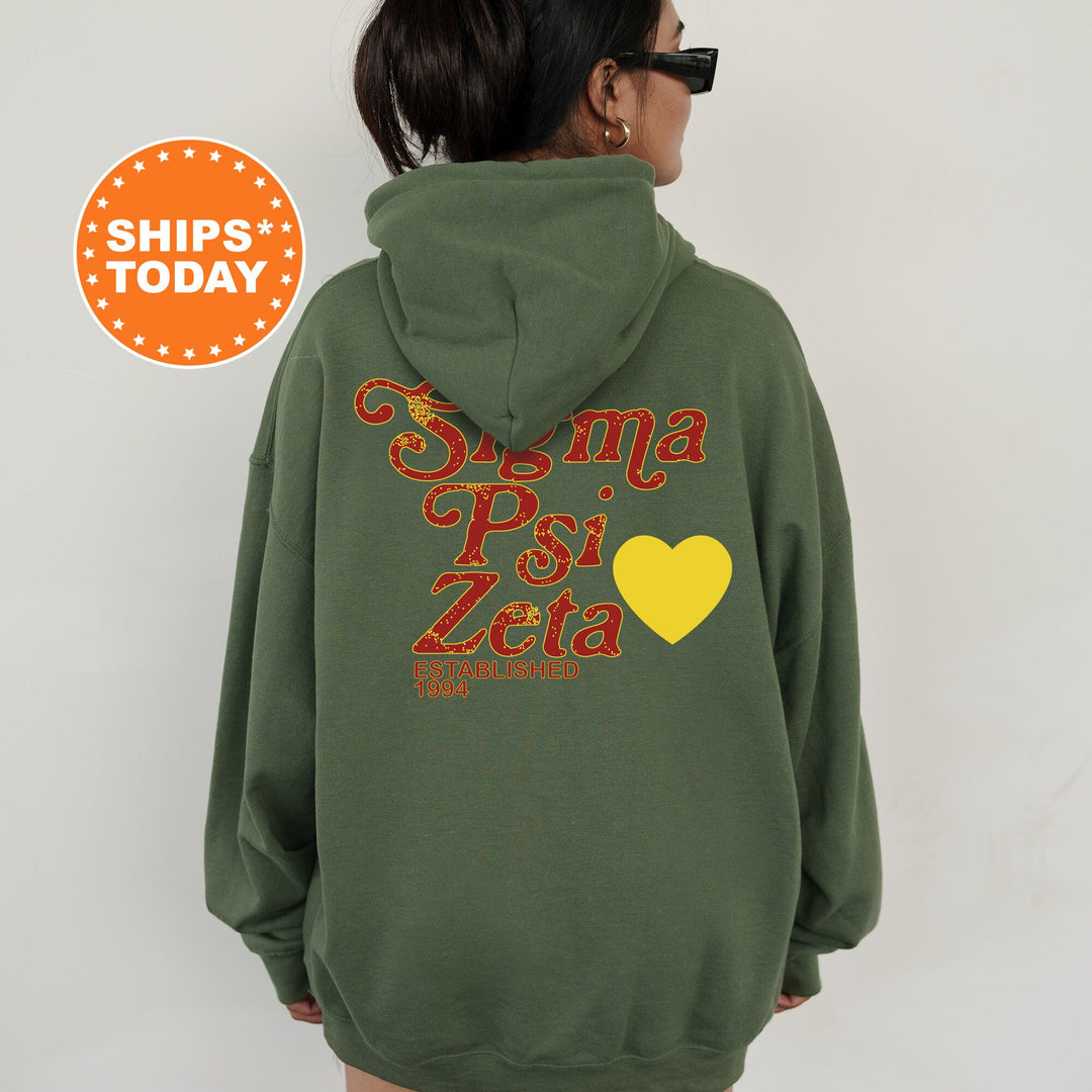 a woman wearing a green hoodie with a yellow heart on it