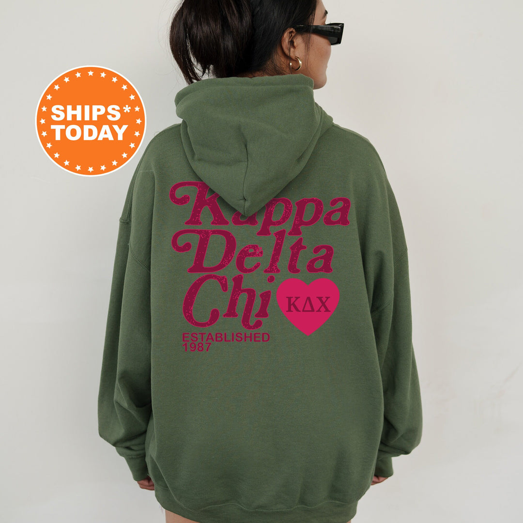 a woman wearing a green hoodie with a pink heart on it