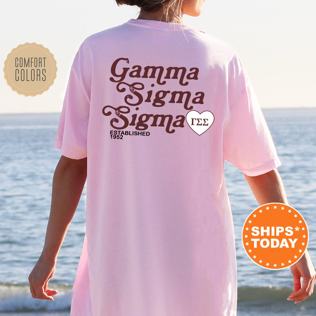 a woman wearing a pink shirt with the words gama sigma on it