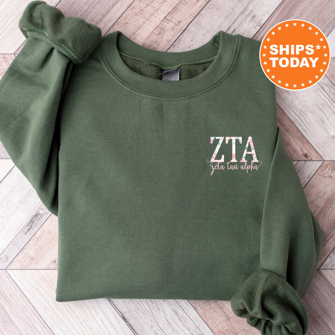 a green sweatshirt with a white zta embroidered on it