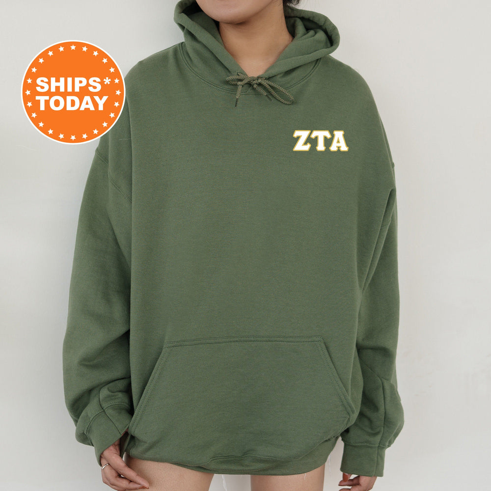 a woman wearing a green hoodie with a yellow zta on it