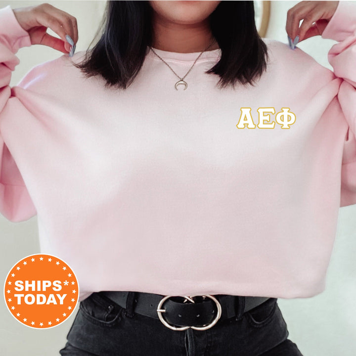 a woman wearing a pink sweatshirt with the letters aep on it
