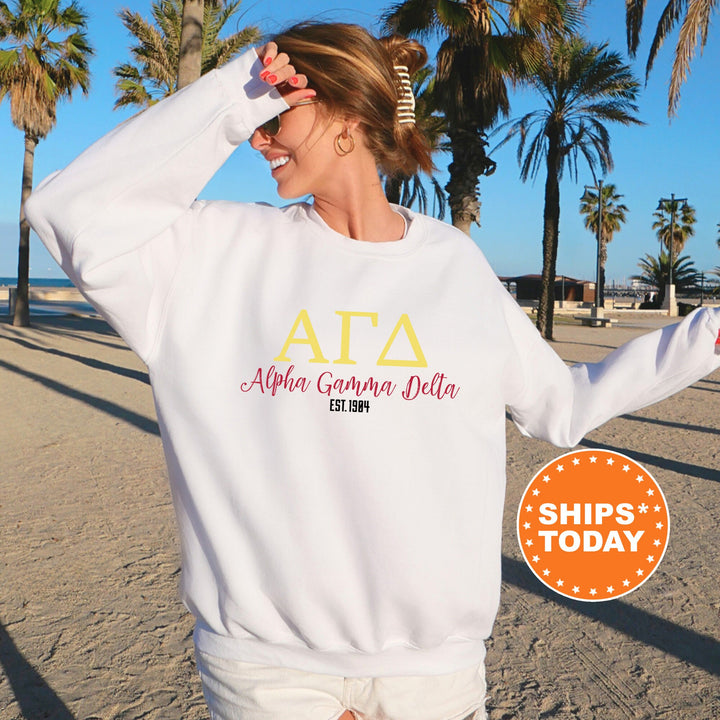 a woman standing on a beach wearing a white sweatshirt