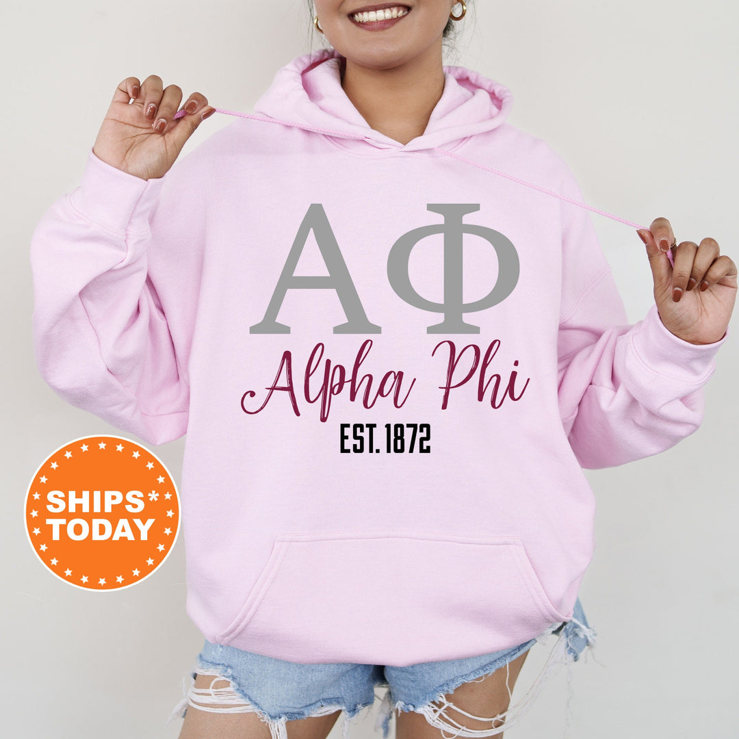 a woman wearing a pink hoodie with a phi phi on it