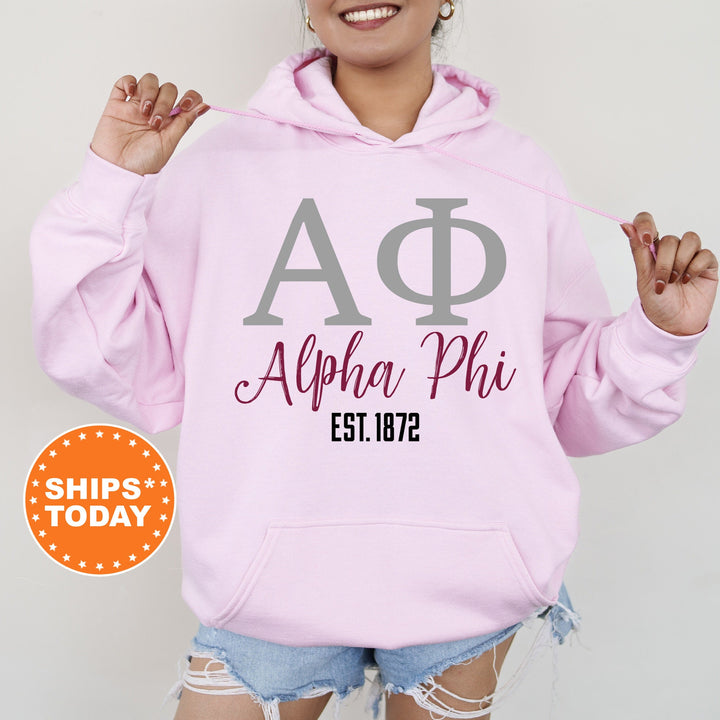 a woman wearing a pink hoodie with a phi phi on it