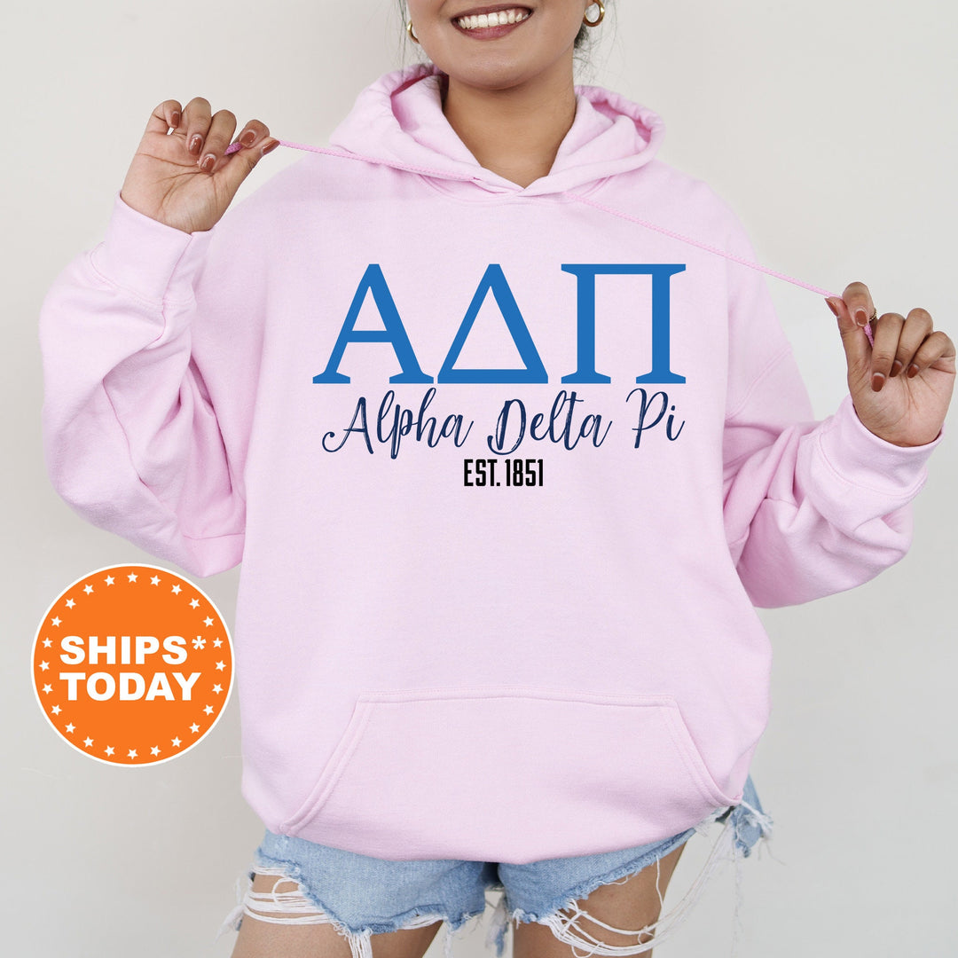 a woman wearing a pink hoodie with the letters delta pi on it