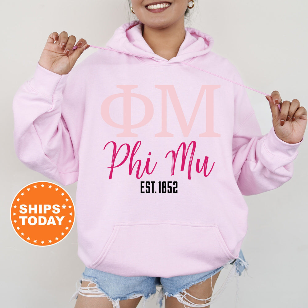 a woman wearing a pink phi mu hoodie